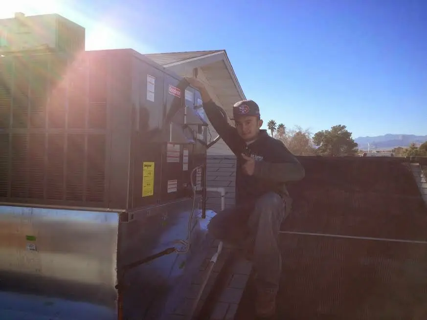 HVAC technician performing Boiler Repair on a rooftop unit in Terre Haute